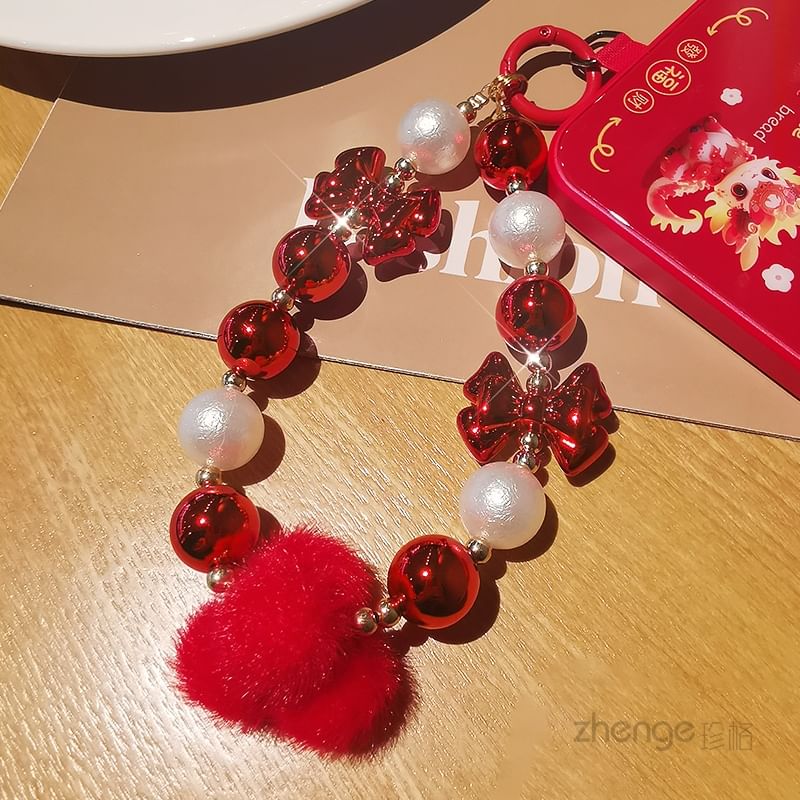 Dragonne de téléphone avec pompon et fausses perles et coussinet pour cordon