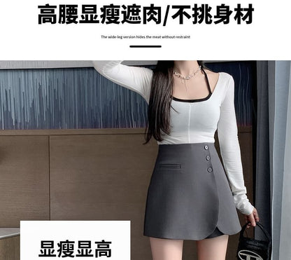 Jupe-short asymétrique taille haute unie boutonnée sur le devant