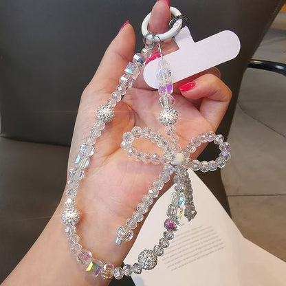 Dragonne de téléphone avec nœud en faux cristal et coussinet pour cordon